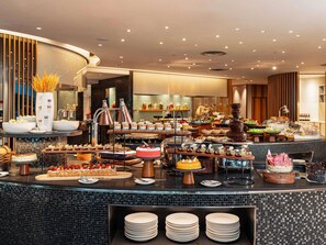 A buffet with various food items and a cake on display. - Novotel Century Hong Kong (Hong Kong)