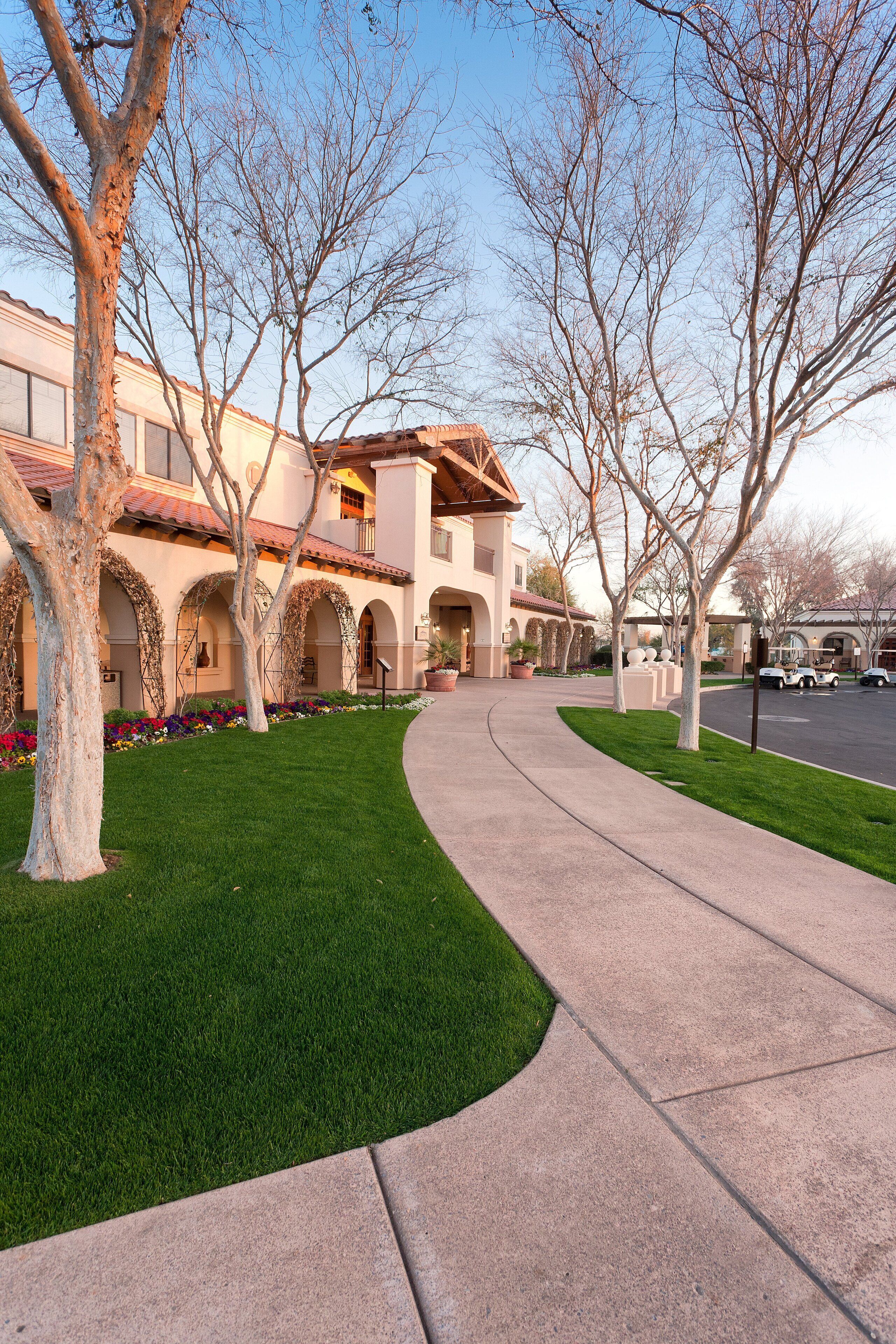 A building with arched walkways and a curved pathway leading to it.
