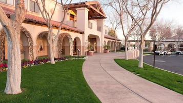 A building with arched walkways and a curved pathway leading to it.