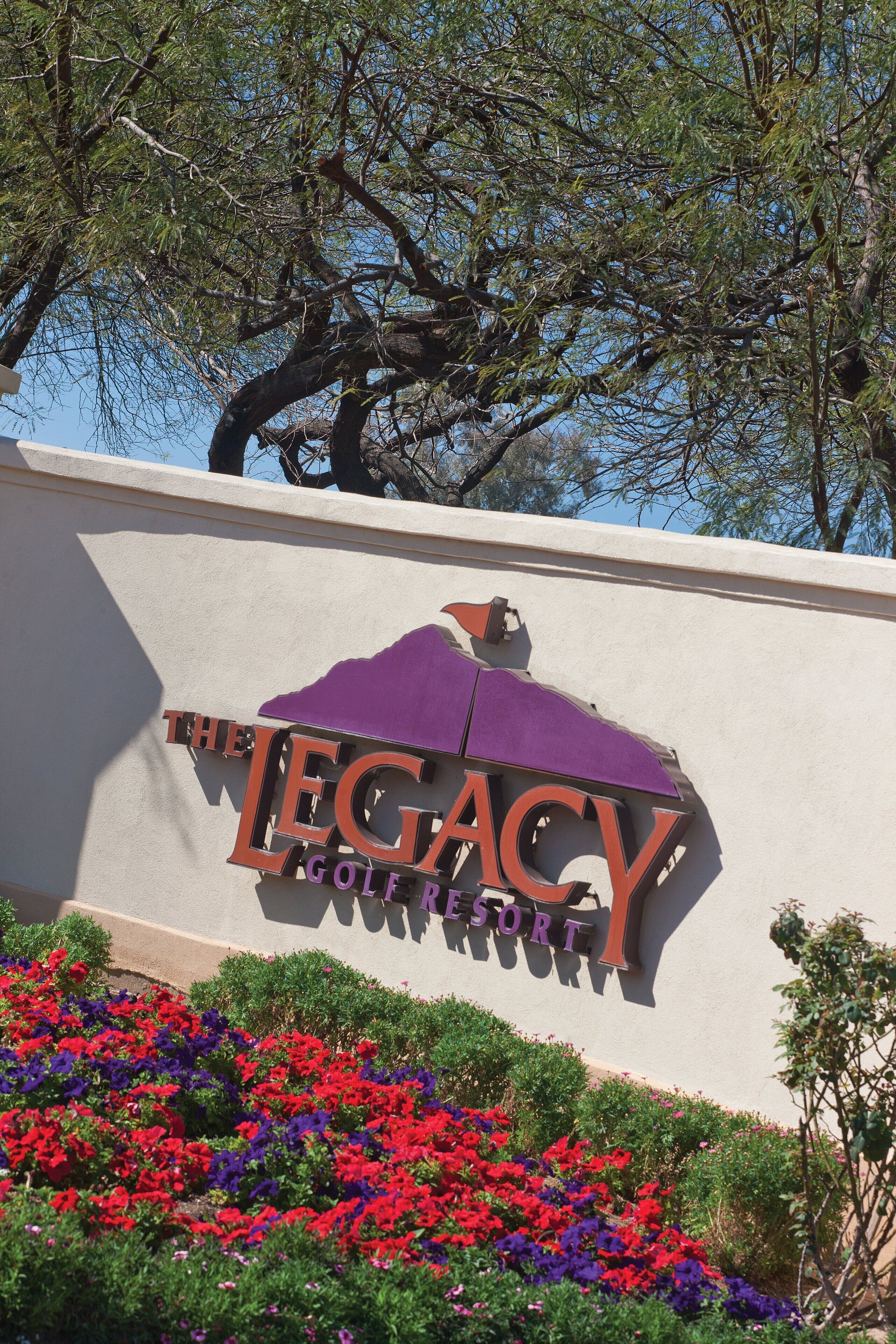 A sign for The Legacy Golf Resort with a mountain silhouette logo.