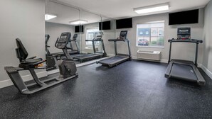 A gym with treadmills, a stationary bike, and a weight bench.