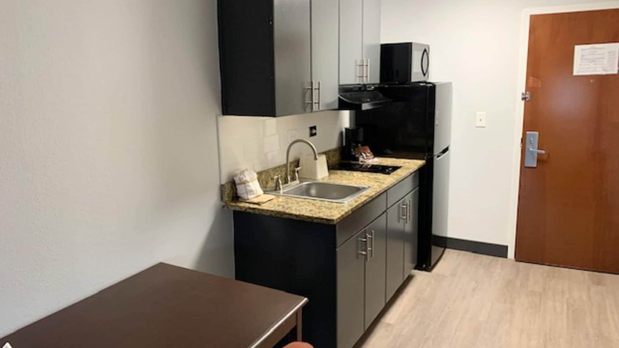 A compact kitchen with a sink, a microwave, and a refrigerator.