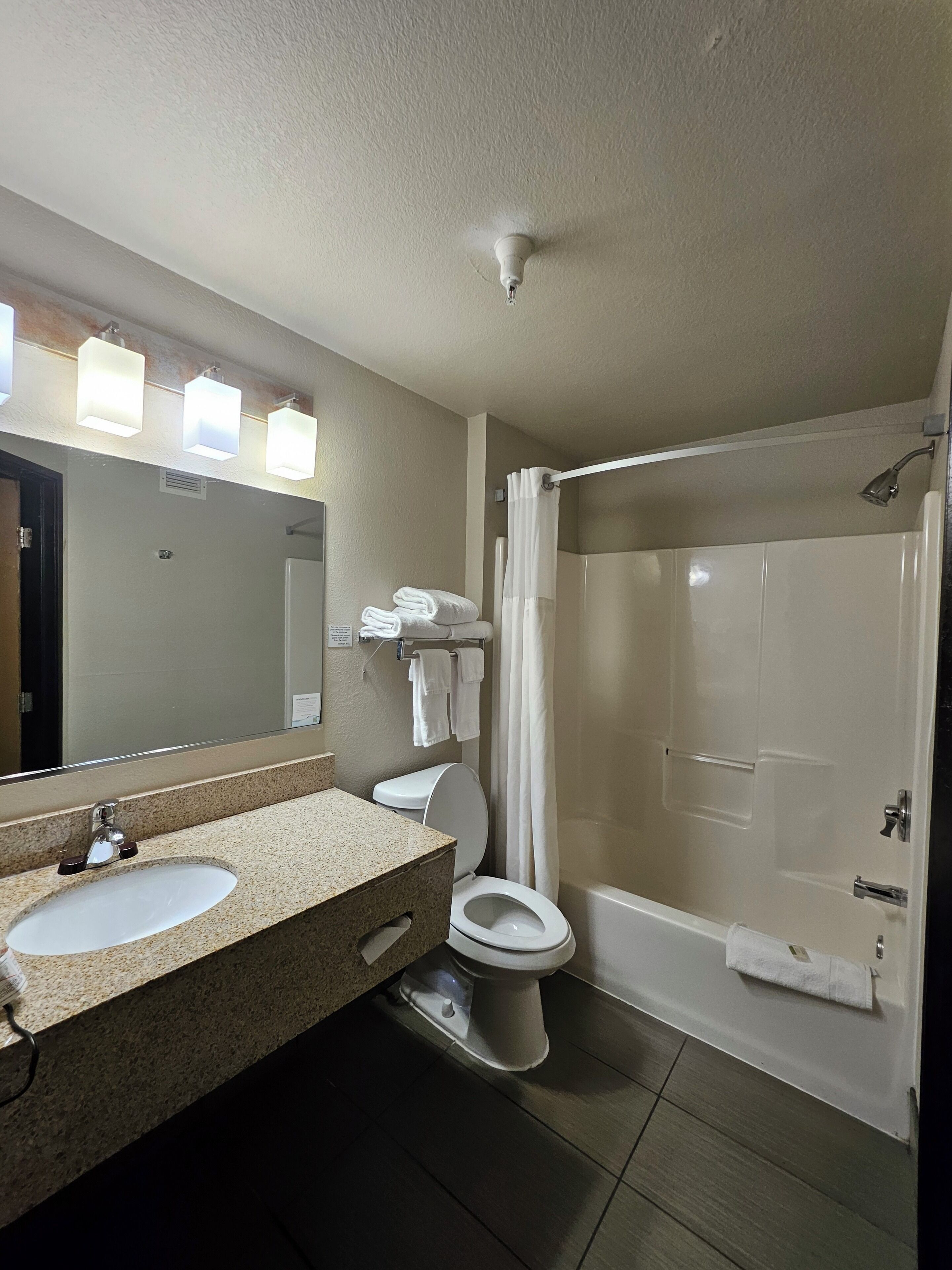 A bathroom with a sink, toilet, and shower.