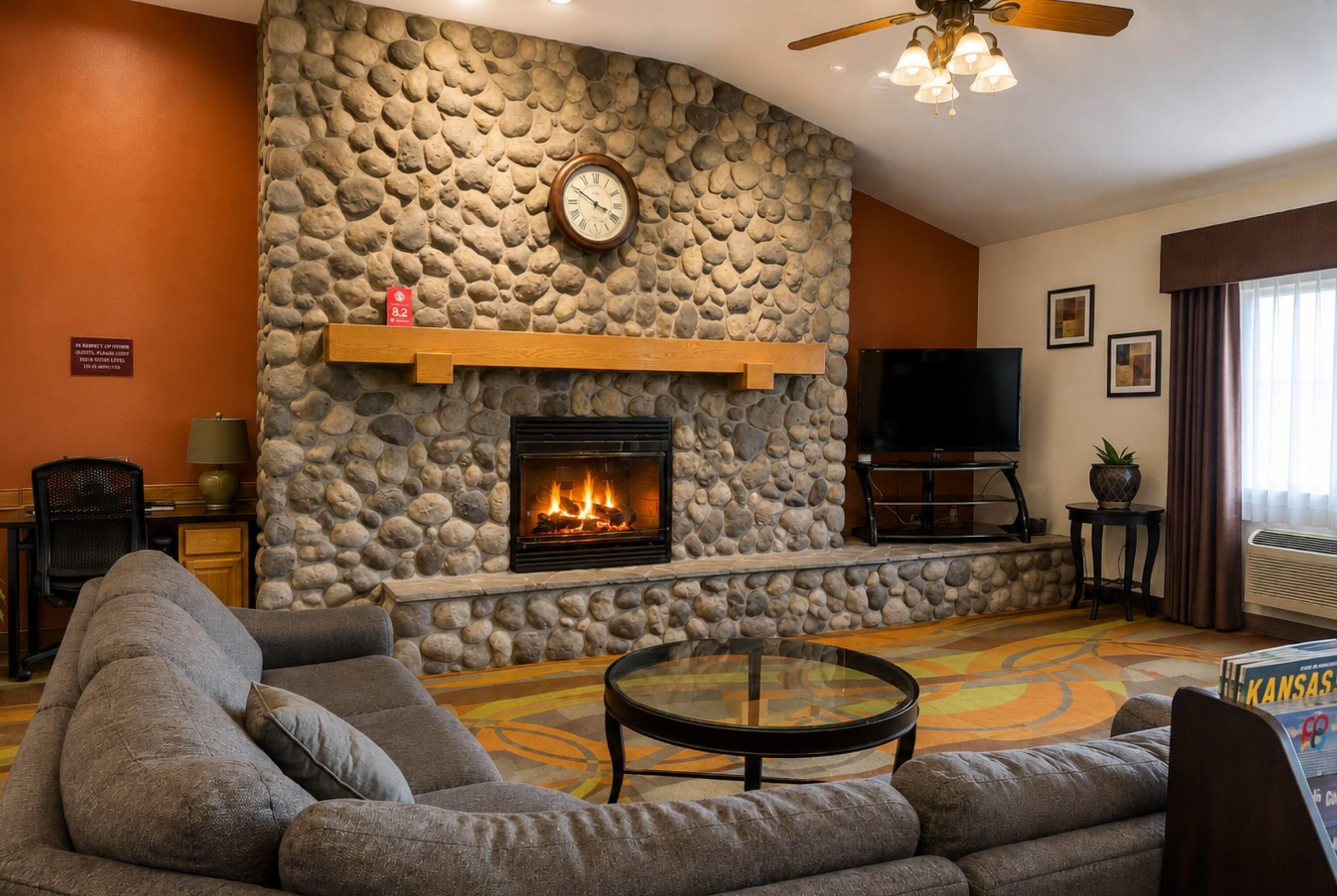 A living room with a stone fireplace, a television, and a sofa.