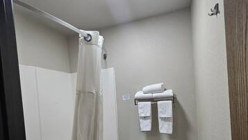 A small bathroom with a shower, toilet, and a towel rack.