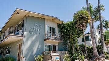 Un edificio de dos pisos con balcones, con la leyenda "INN AT EAST BEACH".