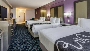 A hotel room with three beds, a TV, a desk, and a bathroom. - La Quinta Inn & Suites by Wyndham Kansas City Airport (Kansas City)