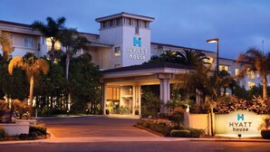 A Hyatt House hotel entrance with a covered walkway, palm trees, and well-lit signage. - HYATT house San Diego/Sorrento Mesa (San Diego)