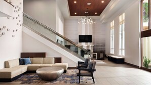 A spacious living area with a large sofa, a coffee table, and a staircase leading to an upper level. - HYATT house San Diego/Sorrento Mesa (San Diego)