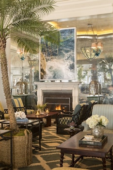 A beach with rows of orange beach chairs and striped umbrellas. at Casa Del Mar