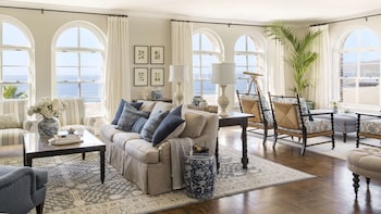A cozy lounge area with a fireplace, comfortable seating, and decorative elements like a large painting and hanging lanterns. at Casa Del Mar