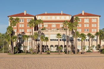 A large conference room with rows of tables and chairs, chandeliers, and a patterned carpet. at Casa Del Mar