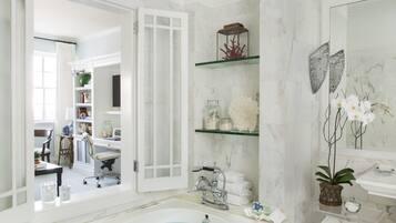Un bagno spazioso con una grande vasca da bagno, uno spazio doccia in vetro e un mobile lavabo con specchio.