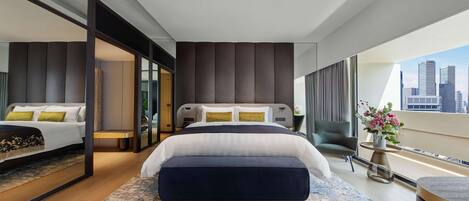 A modern hotel room with a large bed, a seating area with a chair, and a view of the city skyline.