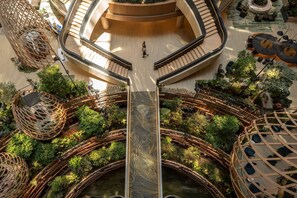 A multi-level atrium with a central staircase, interconnected walkways, and a variety of seating areas. - PARKROYAL COLLECTION Marina Bay, Singapore (Singapore)