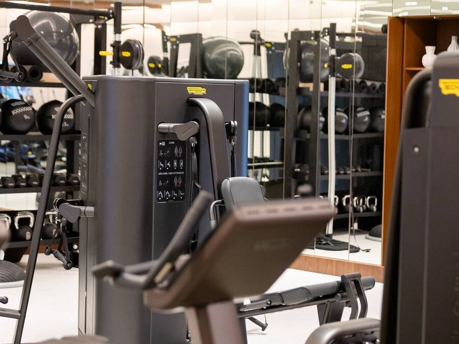 A gym with various exercise machines, including a leg press and a chest press machine.