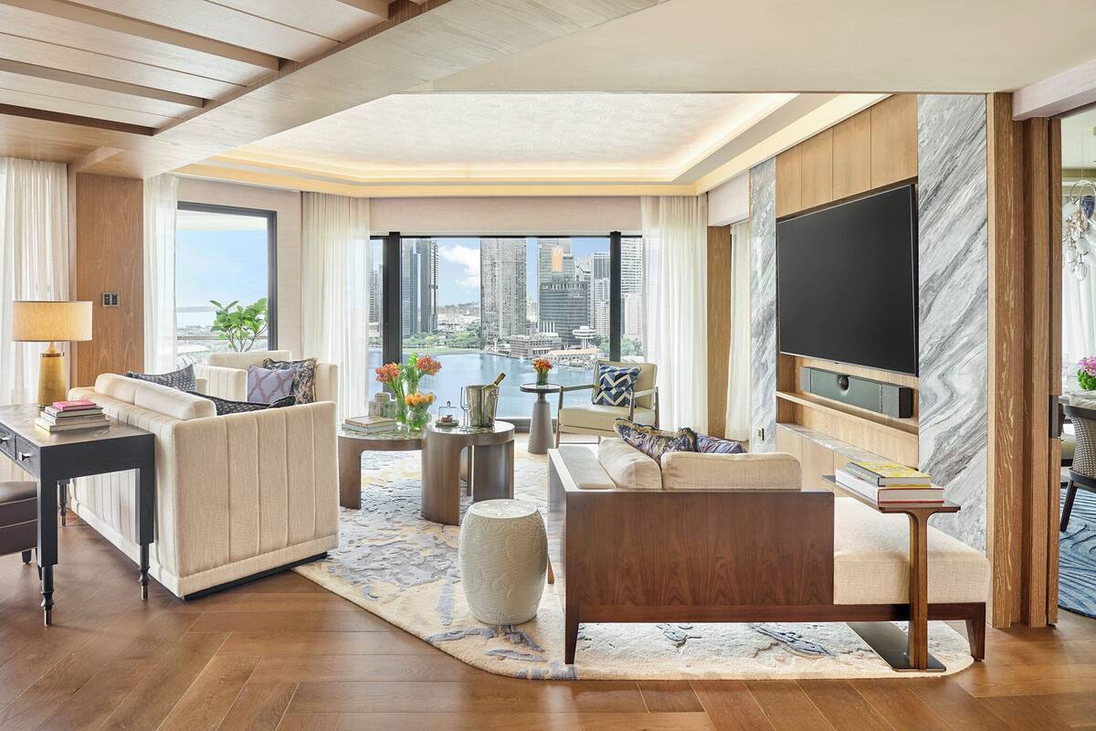 Amplio salón con televisor grande, asientos cómodos, vistas a la ciudad y un diseño moderno.