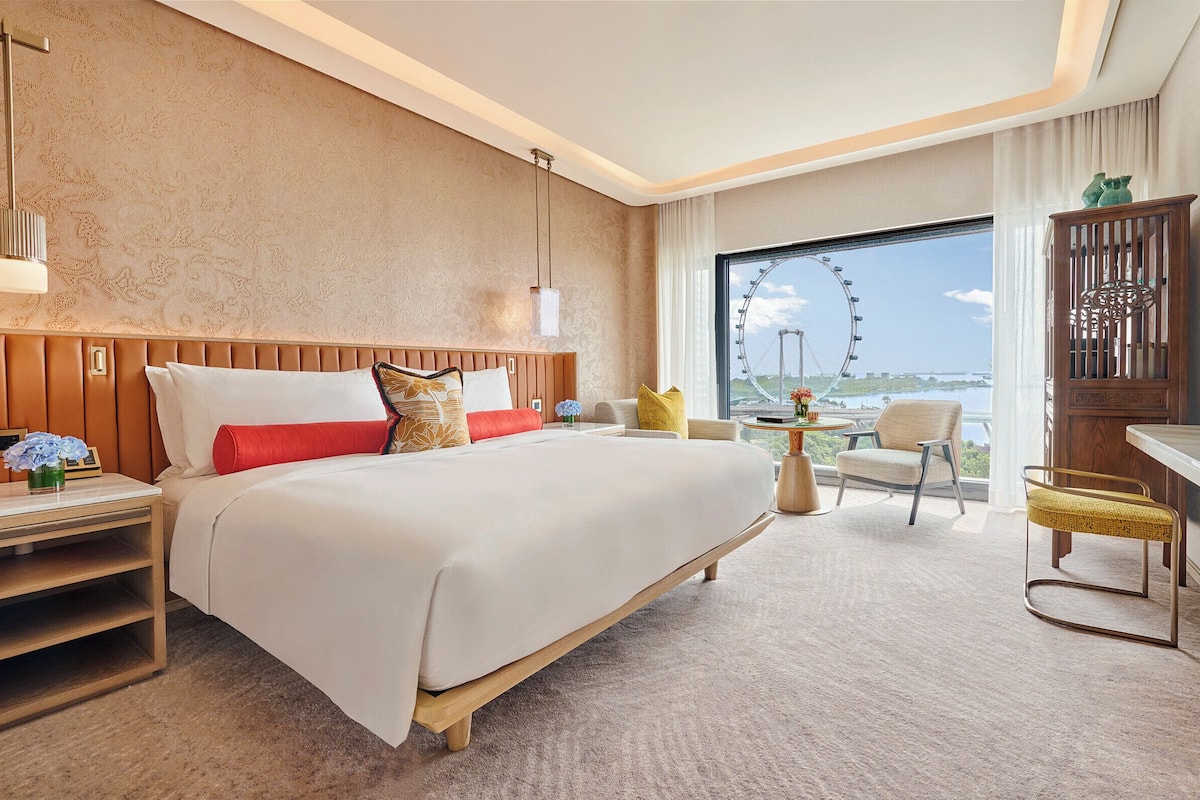 Een hotelkamer met een groot bed, een bureau, een stoel en een televisie.