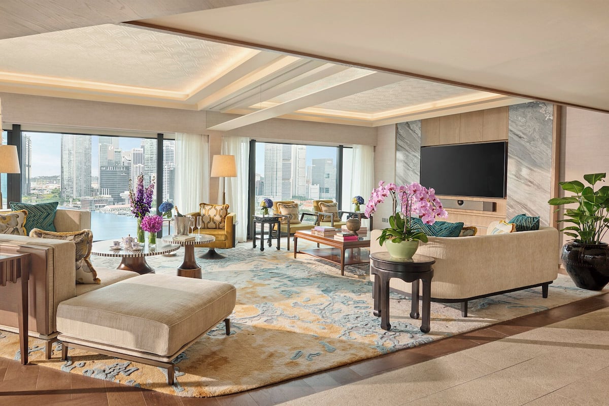 Un salón amplio con vistas a la ciudad, muebles modernos y un televisor de pantalla plana grande.