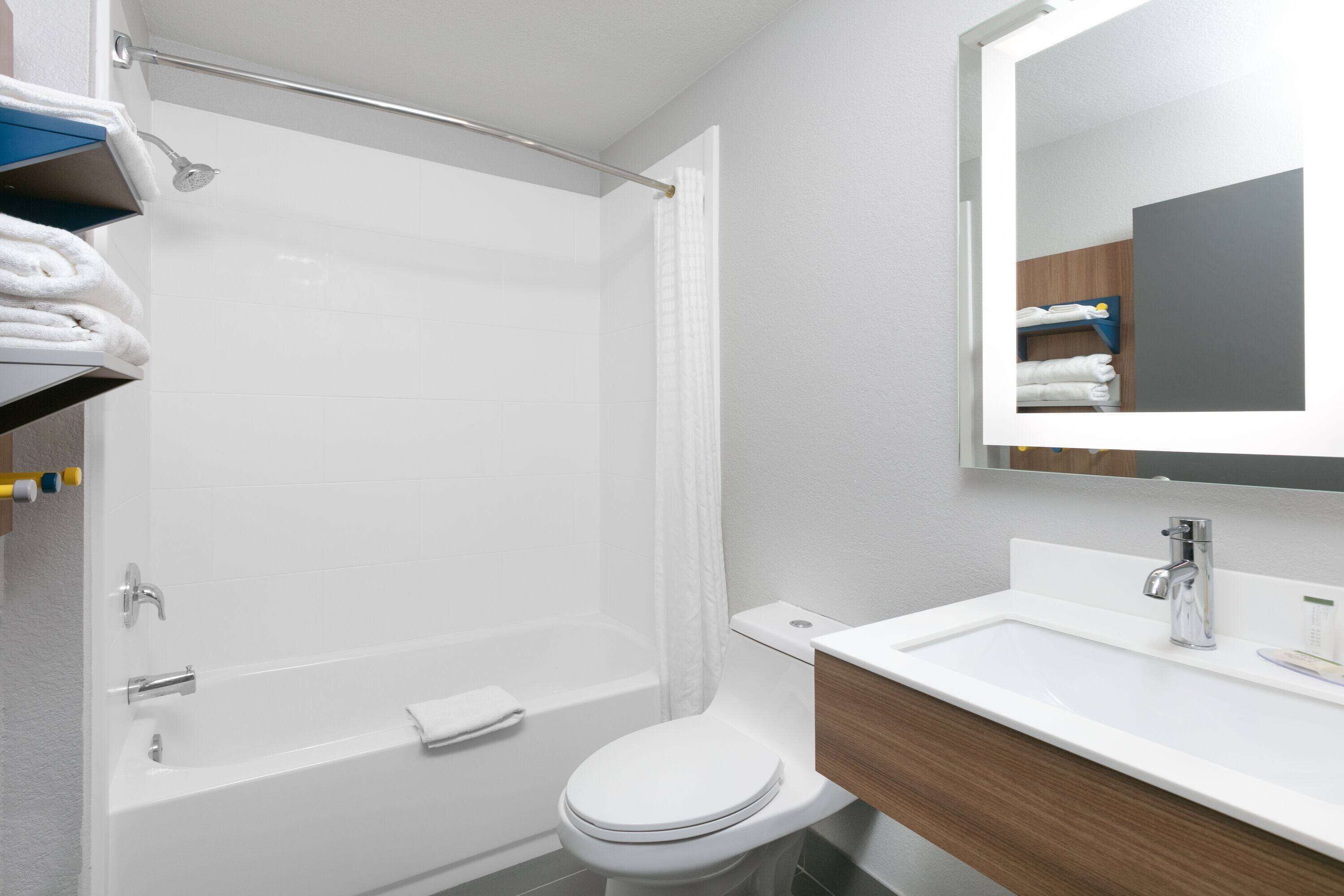 A modern bathroom with a shower, toilet, and sink.