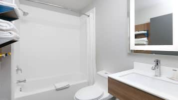 A modern bathroom with a shower, toilet, and sink.