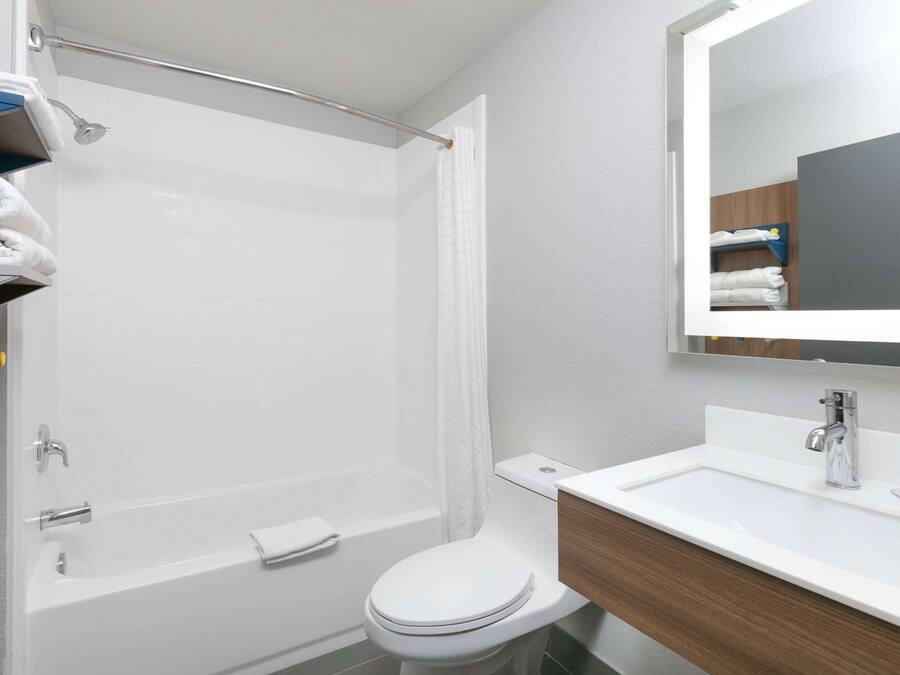 A modern bathroom with a shower, toilet, and sink.