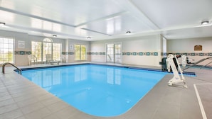 An indoor swimming pool with clear blue water, tiled walls, and a lifeguard chair. - Microtel Inn by Wyndham Beckley (Beckley)