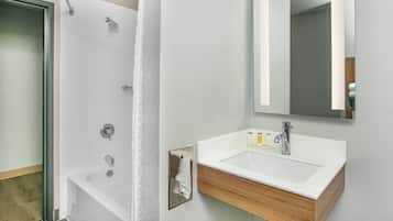 A modern bathroom with a shower, a sink, and a mirror.