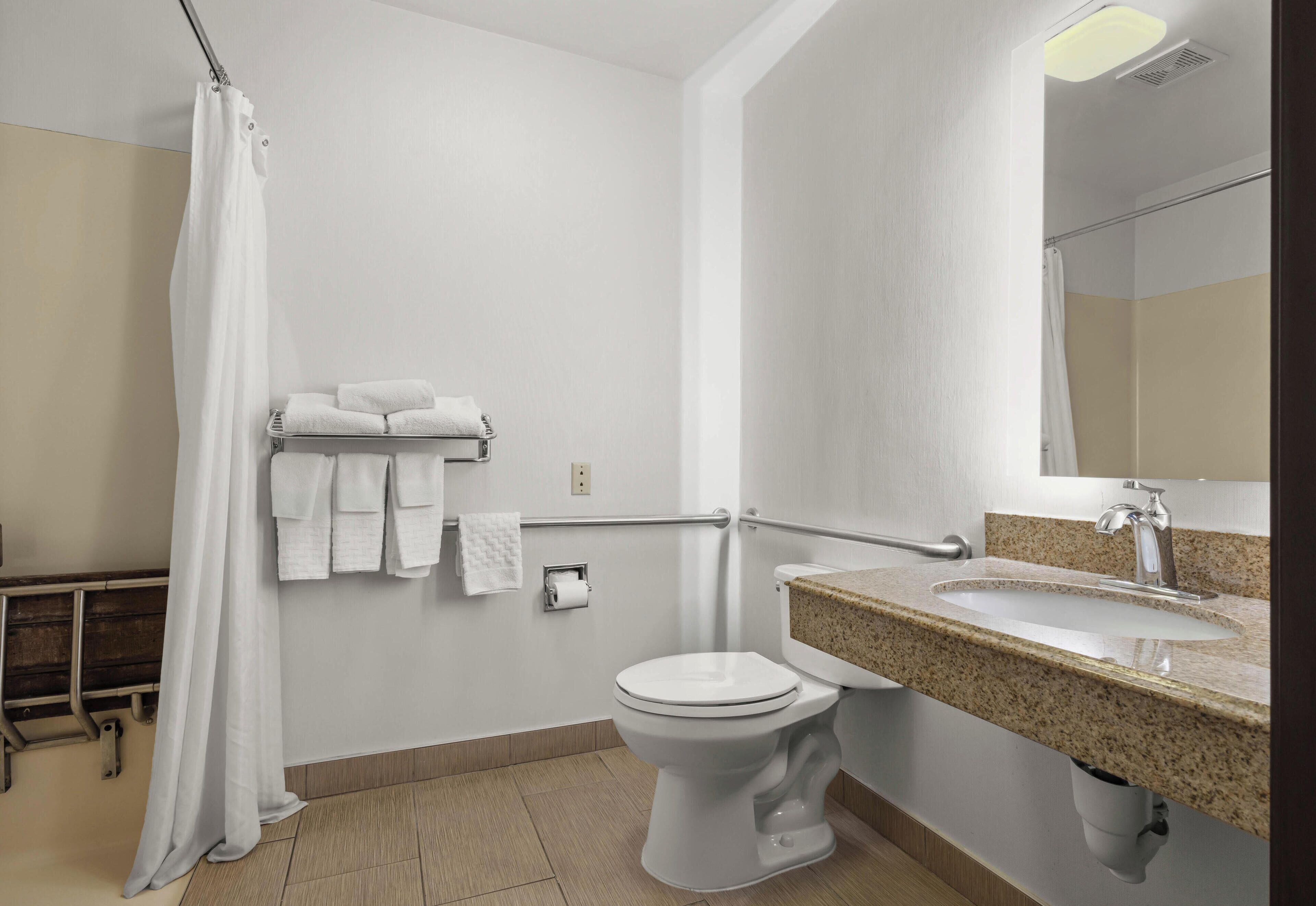 Une salle de bain comprenant des toilettes, un lavabo et un espace douche.