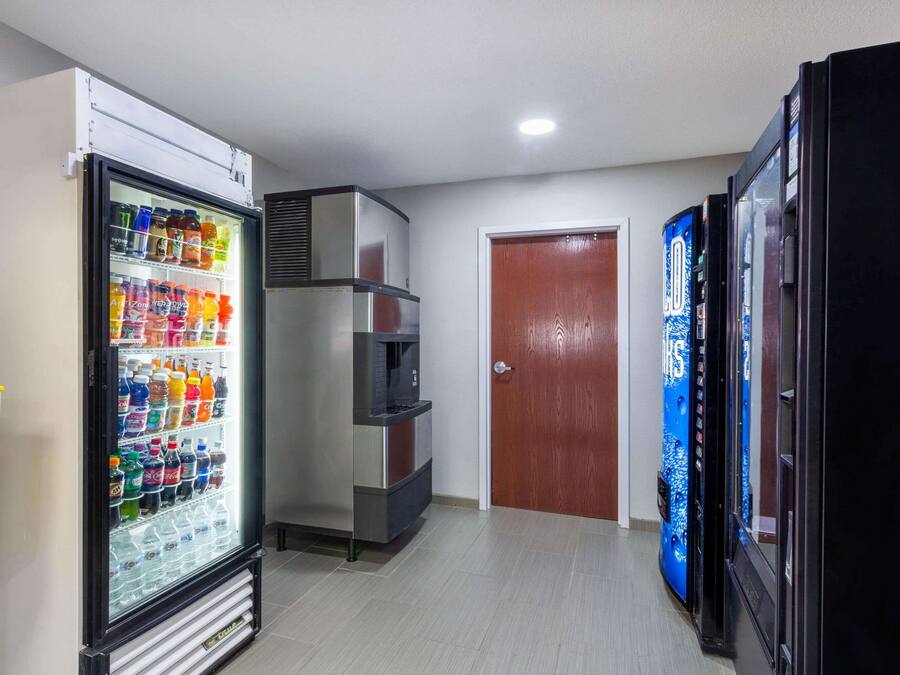 A hallway with a beverage refrigerator, a microwave, and a vending machine.