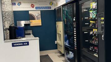 A vending area with a refrigerator stocked with snacks and a vending machine.