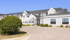 A row of white, single-story buildings with large windows and a covered entrance. - Days Inn by Wyndham Faribault (Faribault)