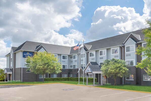 A Microtel hotel with a brick facade, multiple windows, and a parking lot. - Microtel Inn & Suites by Wyndham Eagan/St Paul (Eagan)
