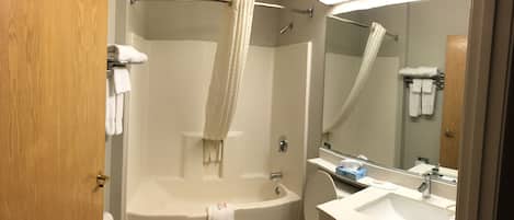 Une salle de bain équipée d’une baignoire, de toilettes, d’un lavabo et d’une douche avec un rideau.
