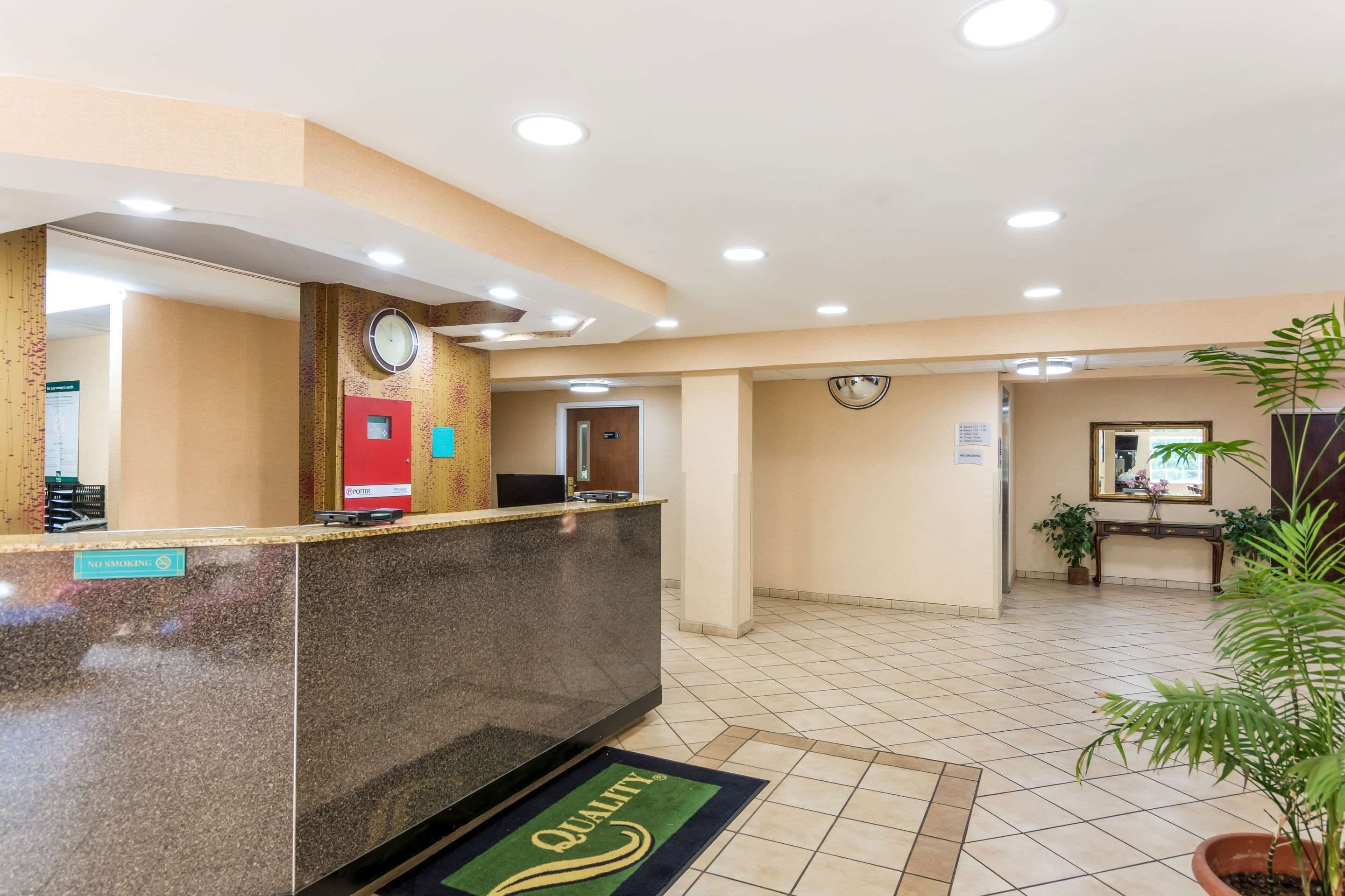 Ein Hotel-Empfangsbereich mit einer Marmor-Theke, einer Uhr und einem Rauchverbot-Schild.