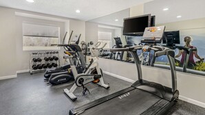 A modern gym with treadmills, elliptical machines, and a weight rack. - Clarion Pointe Staunton East (Staunton)
