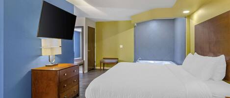 A bedroom with a bed, a TV, a dresser, and a chair.