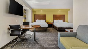 A hotel room with two beds, a desk with a chair, a TV mounted on the wall, and a sofa. - Clarion Pointe Staunton East (Staunton)