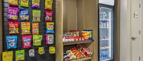 A snack display with various brands and a refrigerated section with beverages.