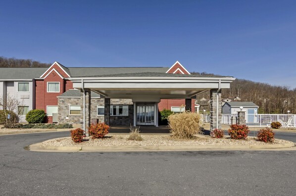 A two-story building with a covered entrance and a stone facade.