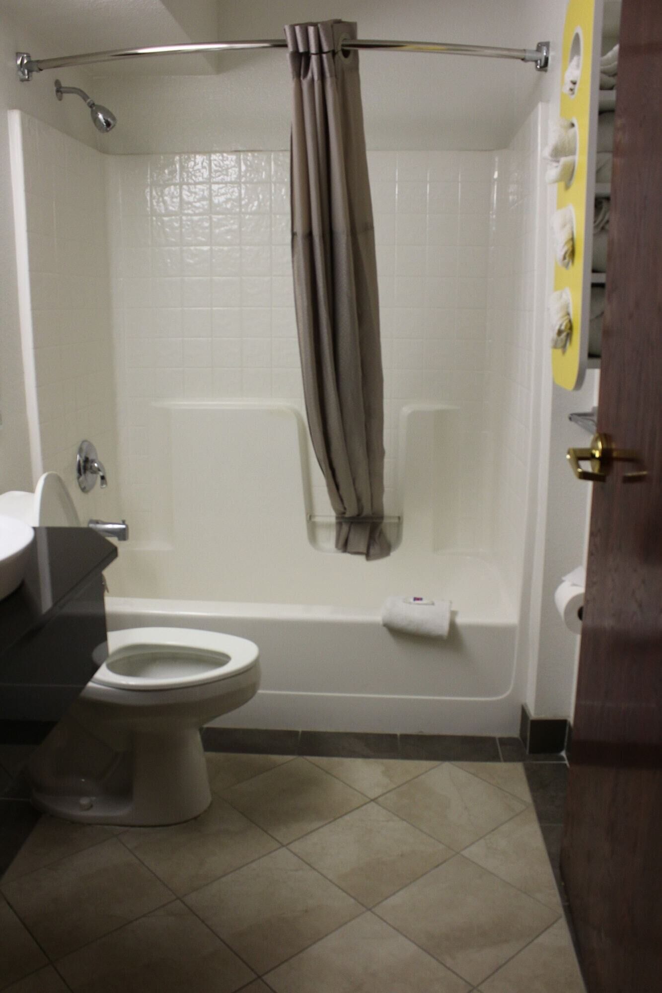 Een badkamer met toilet, bad en douchegordijn.