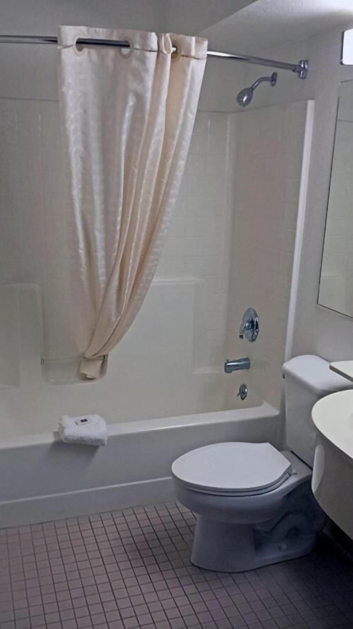 Un baño con ducha, inodoro y lavamanos.
