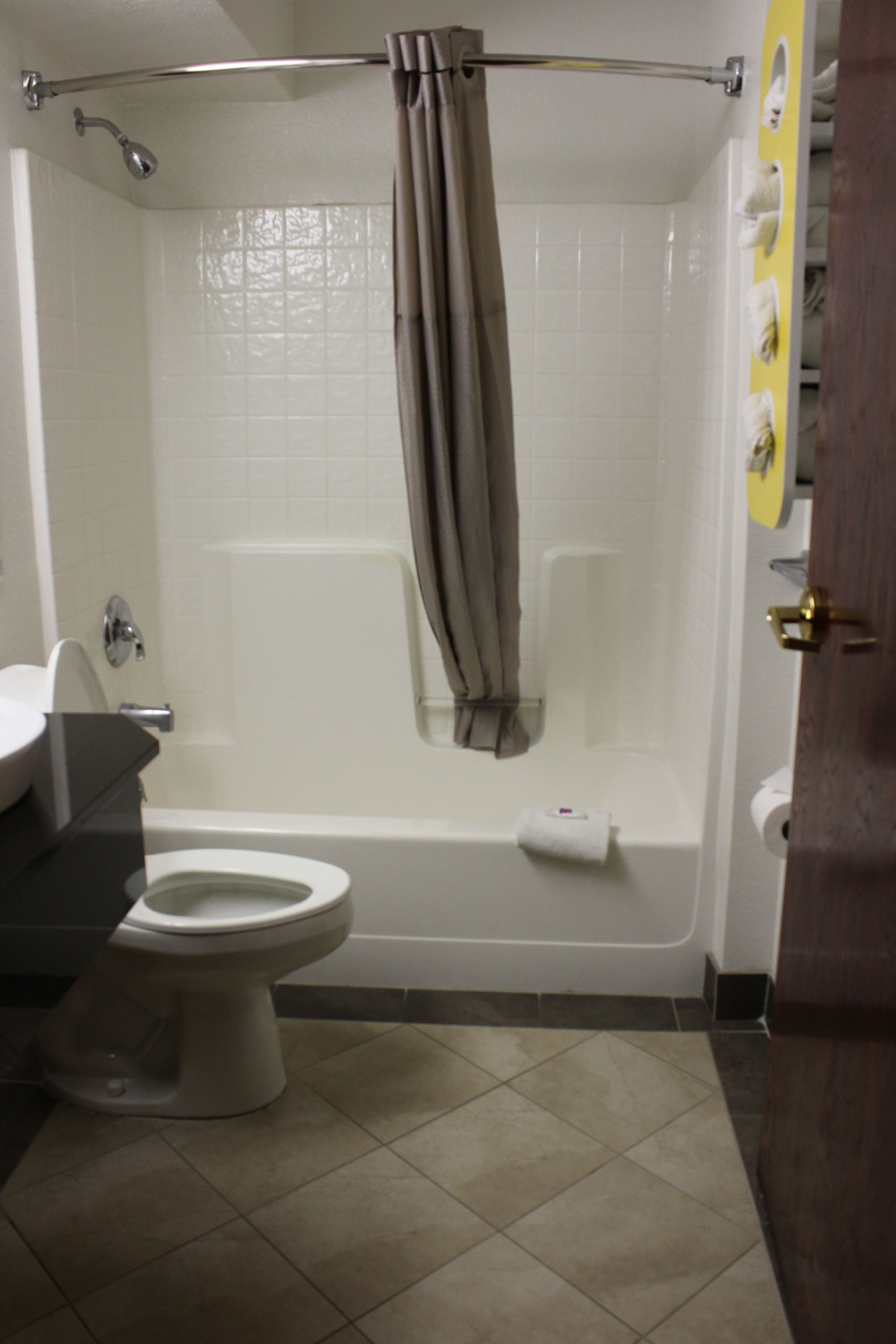 Une salle de bain équipée de toilettes, d’un lavabo, d’une baignoire et d’un rideau de douche.
