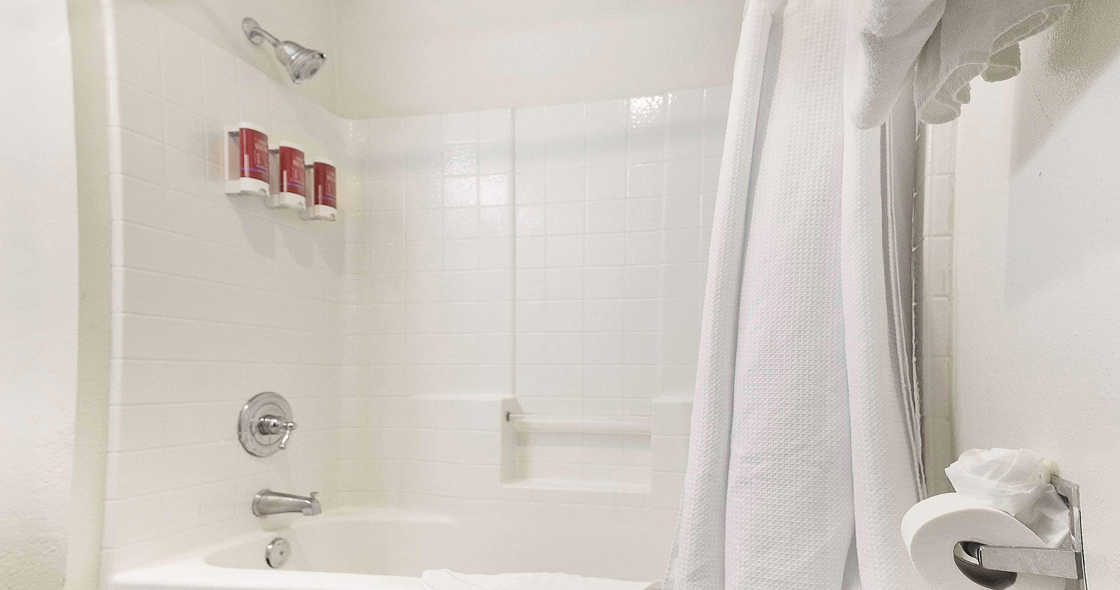 Ein Badezimmer mit einer Badewanne, einer Duschvorhang und einem Handtuchhalter mit einem Handtuch.
