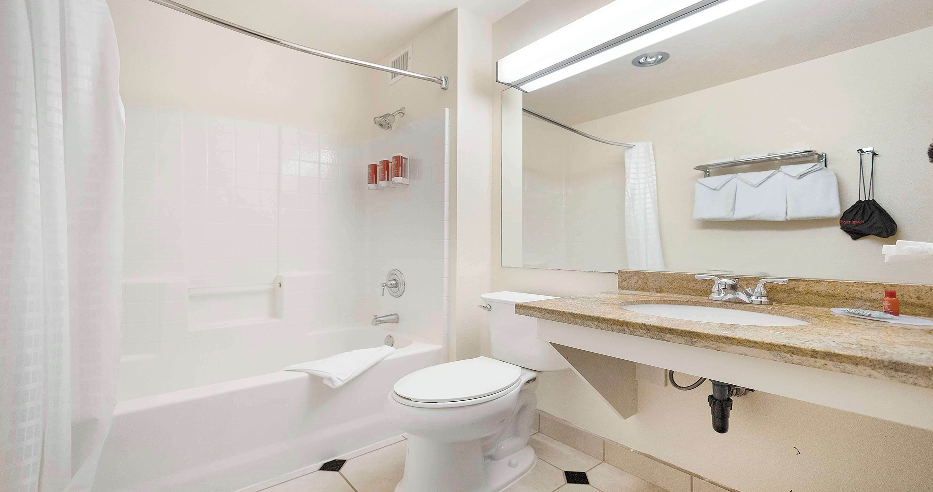 A modern bathroom with a bathtub, toilet, and sink.