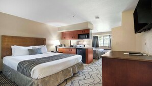 Une chambre d’hôtel équipée d’un lit, d’un bureau, d’une kitchenette et d’un téléviseur.