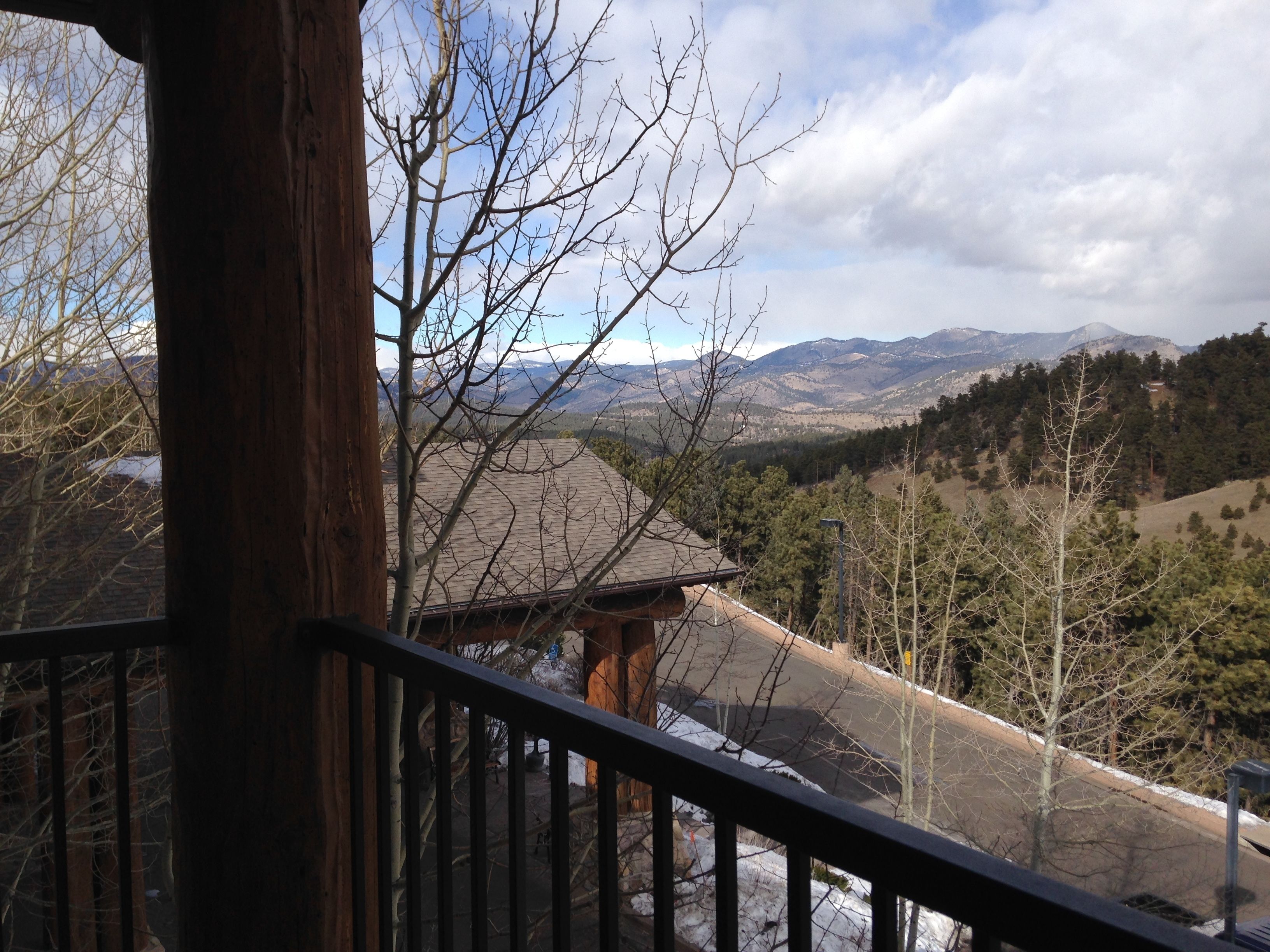 Una terraza de madera con vistas a un paisaje montañoso.