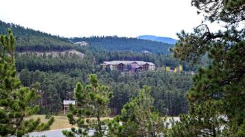 A lodge with a large building surrounded by dense forest and hills.