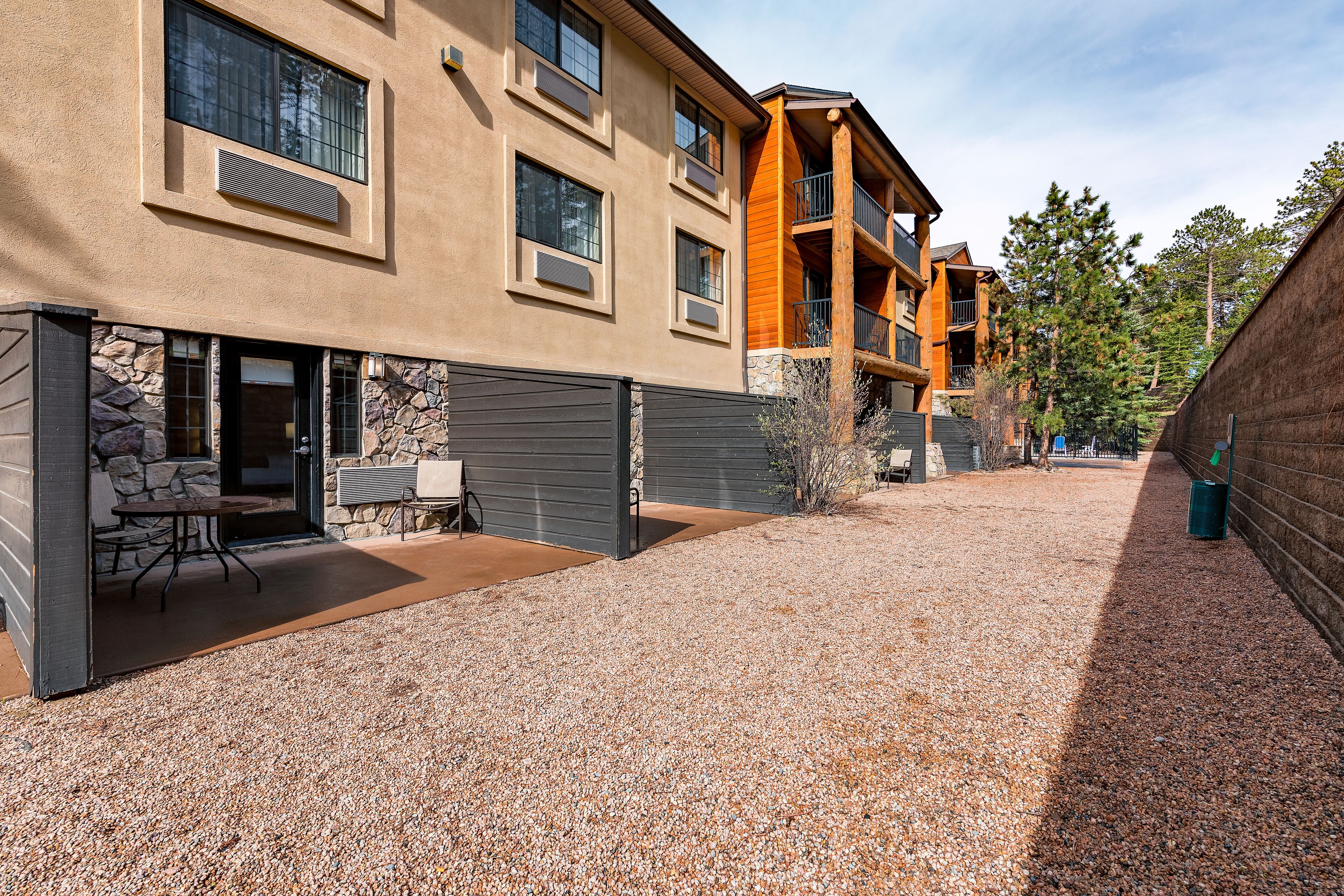 A multi-story building with a stone facade and a gravel courtyard.