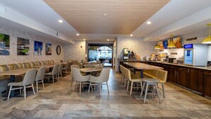 Un restaurant moderne doté d’un long comptoir, de plusieurs espaces de restauration et d’une cuisine ouverte.